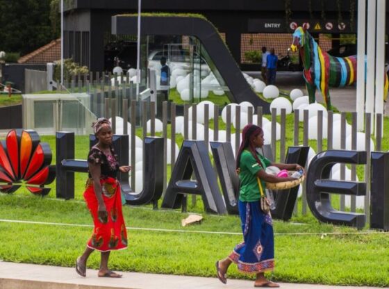 Pedestrians pass by a company logo outside the Huawei Technologies Co. offices in Lusaka, Zambia, on Tuesday, Dec. 11, 2018. Most of the digital infrastructure projects in Zambia, like the more visible airport terminals and highways, are being built and financed by China, putting the country at what the International Monetary Fund calls a high risk of debt distress. Photographer: Waldo Swiegers/Bloomberg via Getty Images