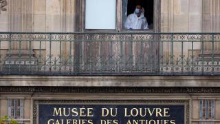 A member of the forensic team inspects one of the windows believed to have been used by thieves to gain access to the Louvre Museum.