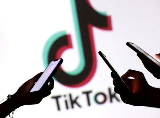 FILE PHOTO: Teenagers pose for a photo while holding smartphones in front of a TikTok logo in this illustration taken September 11, 2025. REUTERS/Dado Ruvic/Illustration/File Photo