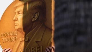 A protester holds a sign with an image depicting US President Donald Trump and the word Nobel written on it.