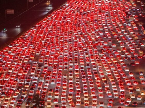 Aerial view of a multi-lane expressway filled with cars merging onto it.