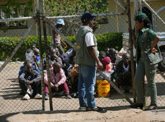 Prison officials stand outside of the entrance of Chikurubi Maximum prison while waiting for prisoners to be released, on the outskirts of the capital Harare, Thursday, April 18, 2024. Zimbabwe President Emmerson Mnangagwa has granted amnesty to more than 4,000 prisoners in an independence day amnesty. The amnesty coincided with the country's 44th anniversary of independence from white minority rule on Thursday and included some prisoners who were on death row. (AP Photo/Tsvangirayi Mukwazhi)