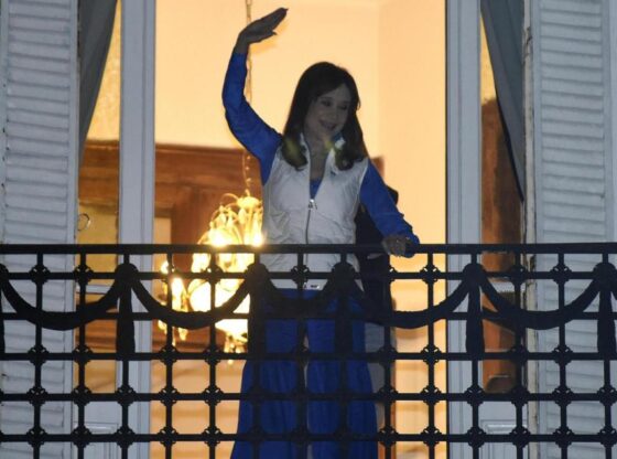 The former president of Argentina Cristina Fernández de Kirchner waves from the balcony of her house, where she is under house arrest.